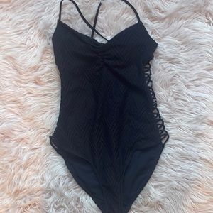 Black Target one piece. SIZE M. Open back and braided sides.